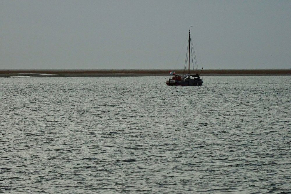 Zeilboot op de Waddenzee in de schemering